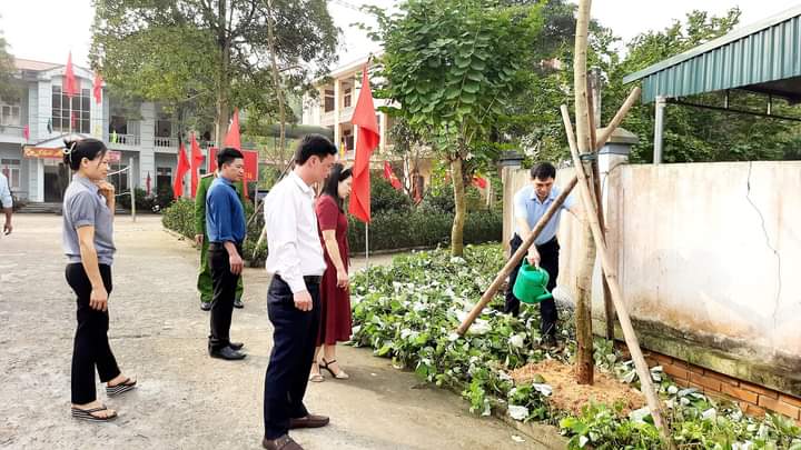 Đồng chí Trần Văn Tường - Bí thư Đảng ủy xã tưới cây tại khuôn viên cơ quan